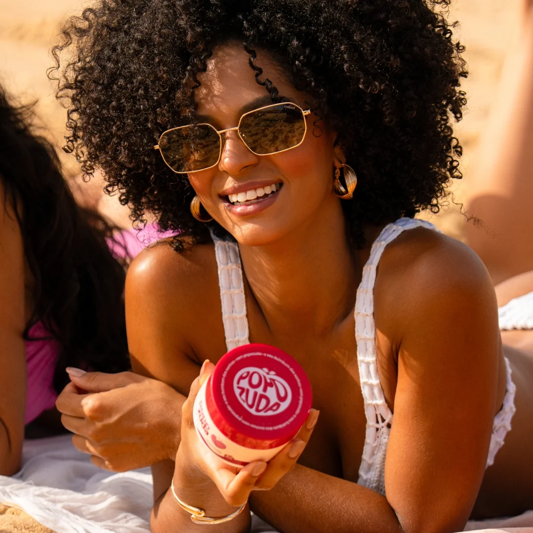 Modelo segurando o Creme Popozuda na praia